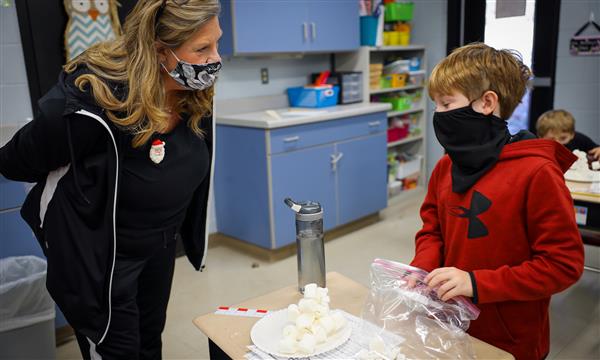 Teacher helps student during STEM challenge
